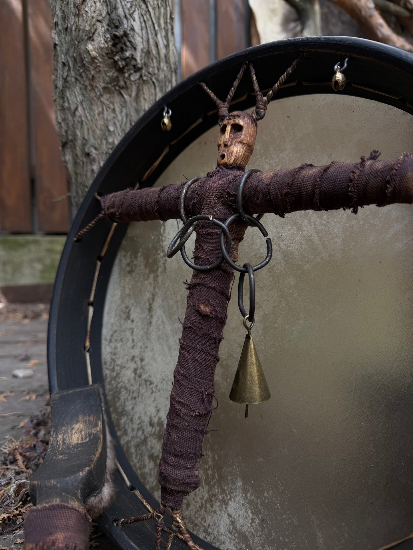 Hand-carved alder spirit head, metal rings and brass bell detail