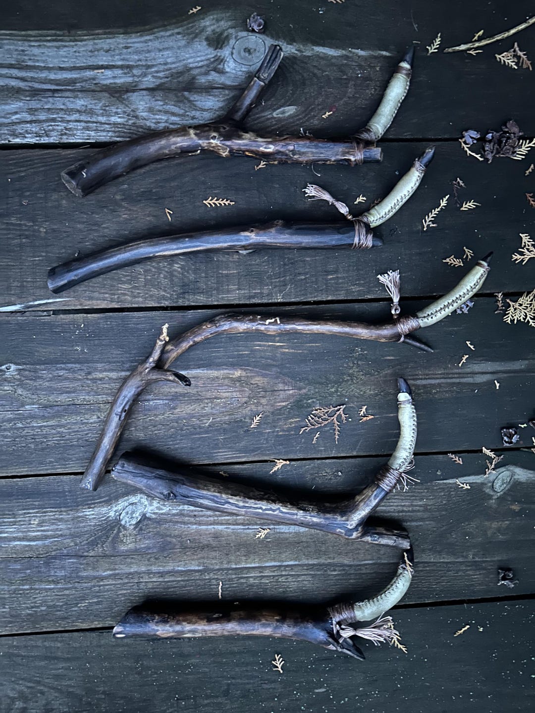 Shaman's finger rattles arranged on weathered boards, showing the range of natural branch shapes