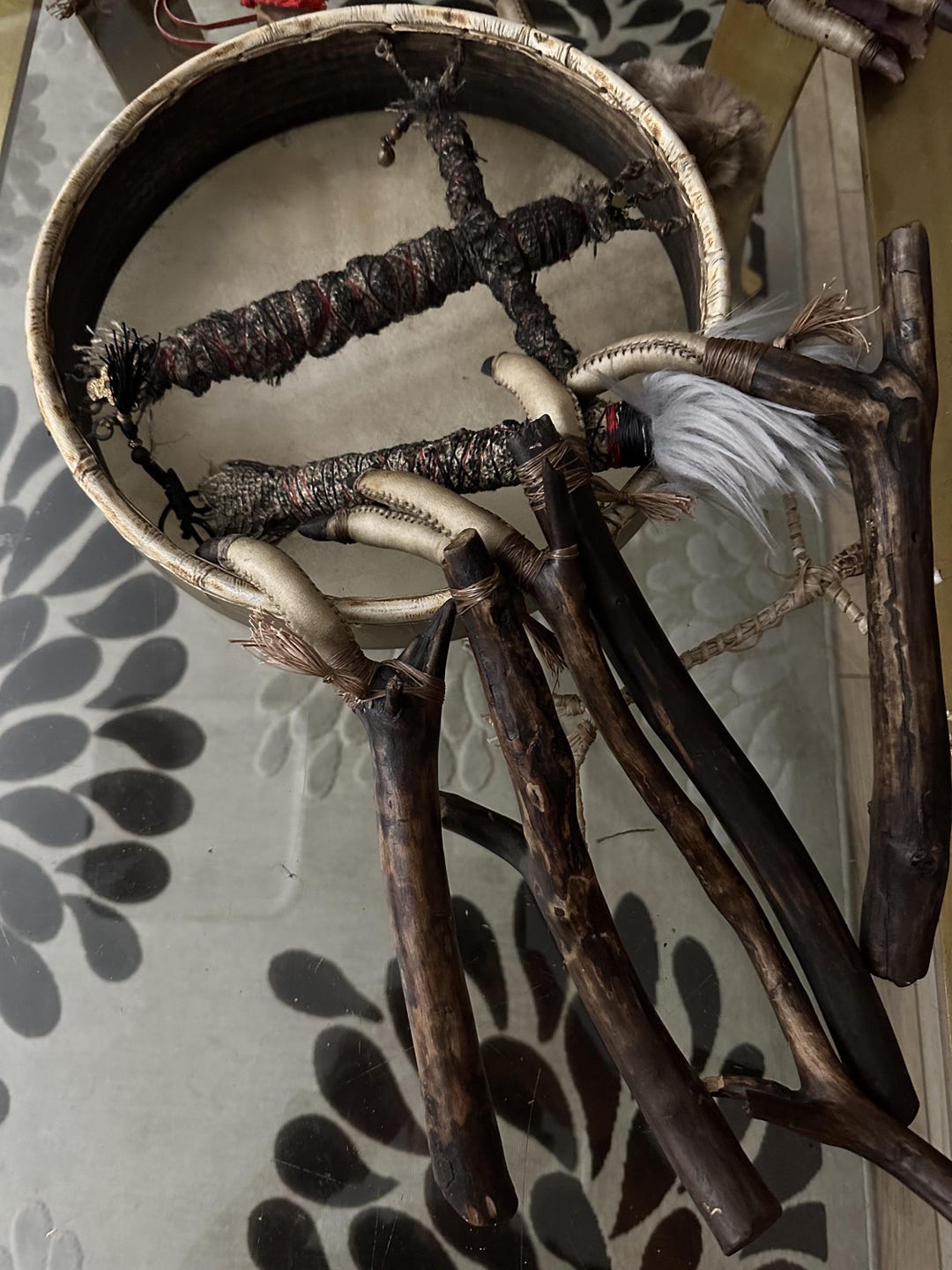 Shaman's finger rattle resting against a hand-laced frame drum